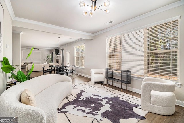 living room featuring light hardwood / wood-style floors, crown molding, and a notable chandelier