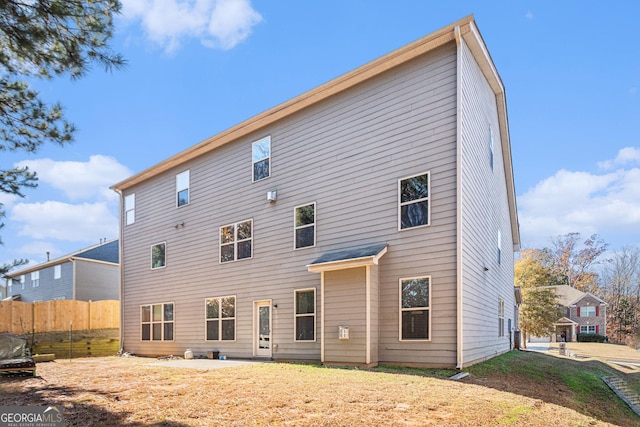 rear view of property featuring a lawn