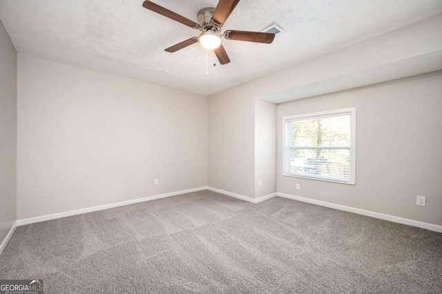 carpeted empty room with ceiling fan and a textured ceiling