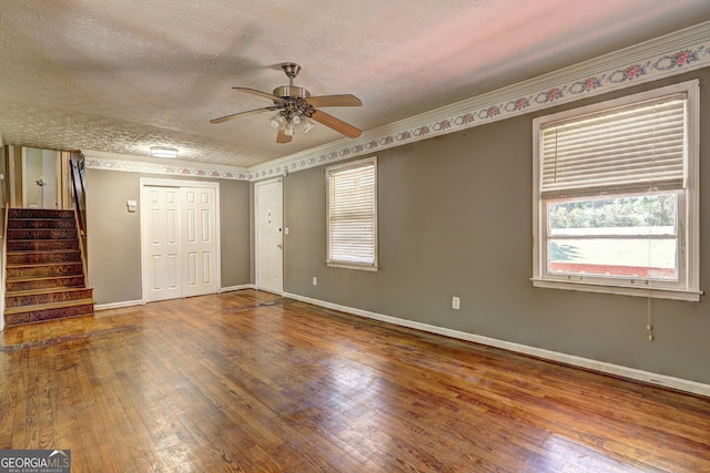 unfurnished room with hardwood / wood-style flooring, ceiling fan, ornamental molding, and a textured ceiling