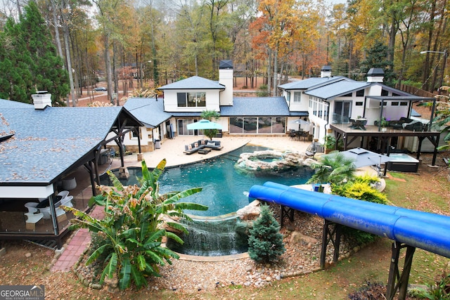 view of swimming pool with a sunroom, an in ground hot tub, a patio, and an outdoor living space