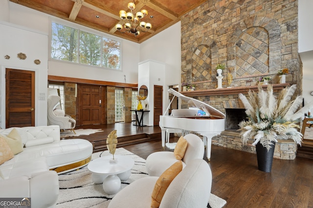 living room featuring an inviting chandelier, a towering ceiling, a fireplace, beamed ceiling, and dark hardwood / wood-style flooring