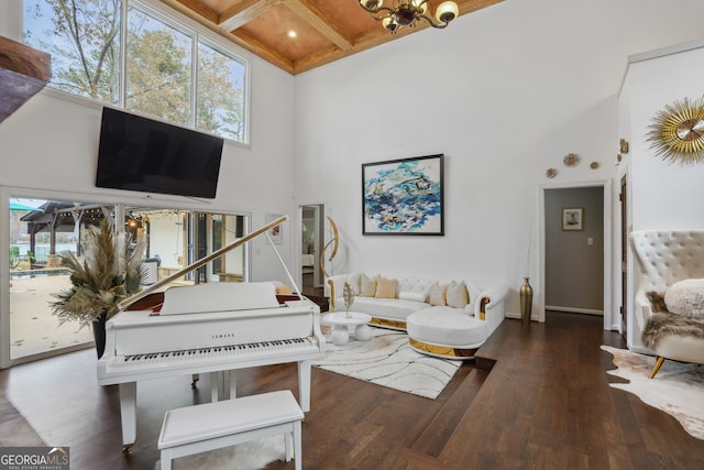 living room featuring beam ceiling, dark wood-type flooring, a high ceiling, and a chandelier