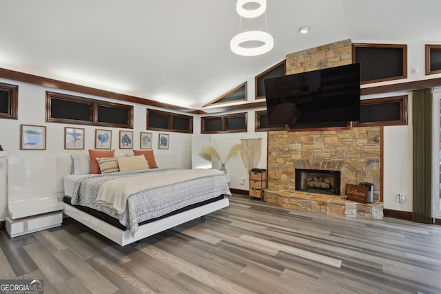 bedroom featuring hardwood / wood-style floors, a fireplace, and high vaulted ceiling