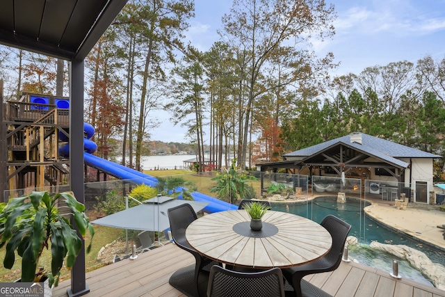 wooden deck featuring a fenced in pool and a water view