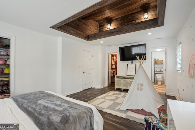 bedroom featuring dark hardwood / wood-style flooring and a tray ceiling