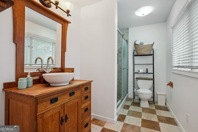 bathroom with vanity, a shower with shower door, and toilet