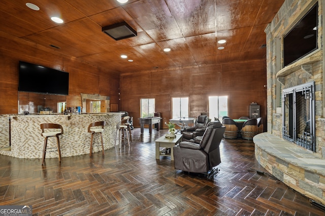 living room with wood walls, dark parquet floors, and wooden ceiling