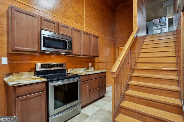 kitchen with wood walls and appliances with stainless steel finishes