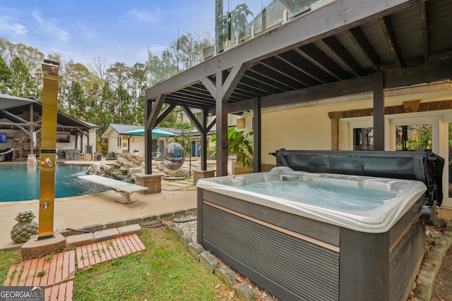 view of patio / terrace with pool water feature and a hot tub