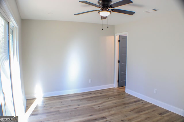 spare room with ceiling fan and light wood-type flooring