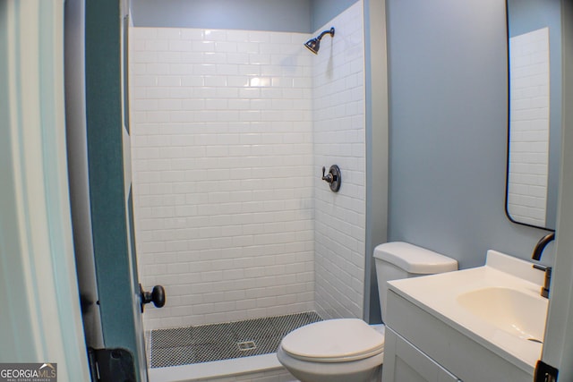 bathroom featuring vanity, toilet, and tiled shower