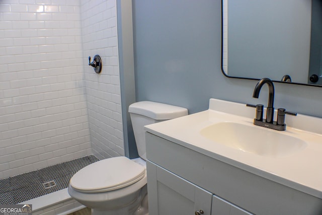 bathroom with toilet, vanity, and walk in shower