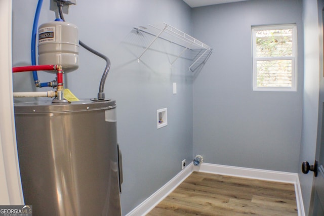 laundry room with water heater, hookup for a washing machine, and hardwood / wood-style flooring