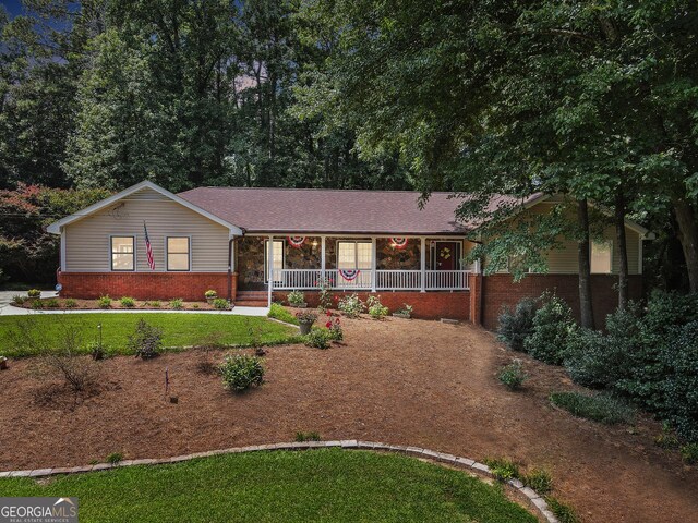 ranch-style home featuring a front lawn and a porch