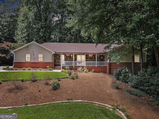 ranch-style house featuring a porch and a front yard