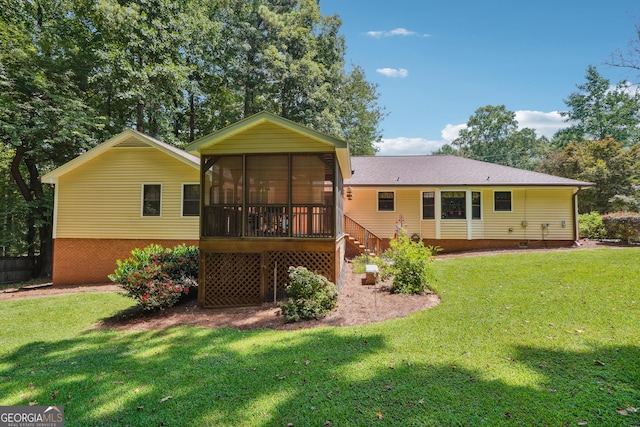 rear view of house with a lawn and a sunroom