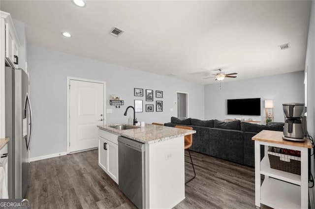 kitchen featuring sink, an island with sink, dark hardwood / wood-style flooring, white cabinetry, and stainless steel appliances