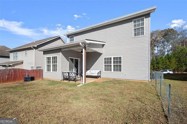 back of property with a patio area and a yard