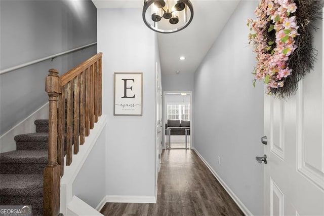 hallway with dark hardwood / wood-style flooring and a chandelier