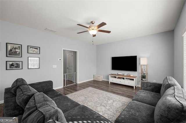 living room with ceiling fan and dark wood-type flooring