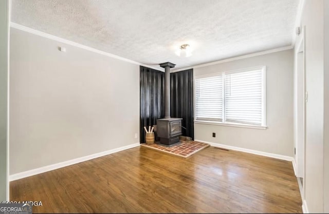 2982 Woodhaven Cir, Macon, GA 31204 - spare room featuring a textured ceiling, a wood stove, ornamental molding, wood finished floors, and baseboards