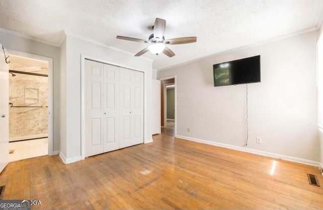 unfurnished bedroom featuring a textured ceiling, light hardwood / wood-style flooring, ceiling fan, and ornamental molding