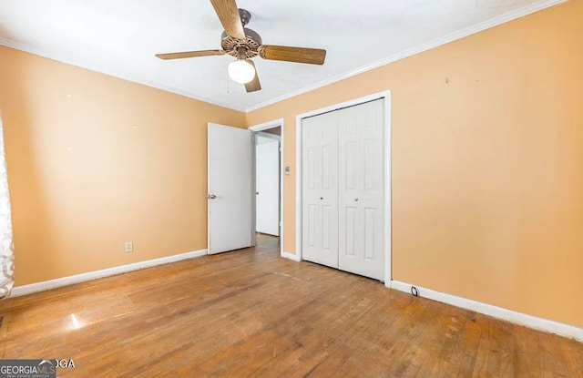 unfurnished bedroom featuring a closet, ceiling fan, crown molding, and wood-type flooring