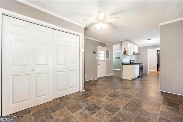 kitchen with ceiling fan, stainless steel range, white cabinets, and ornamental molding