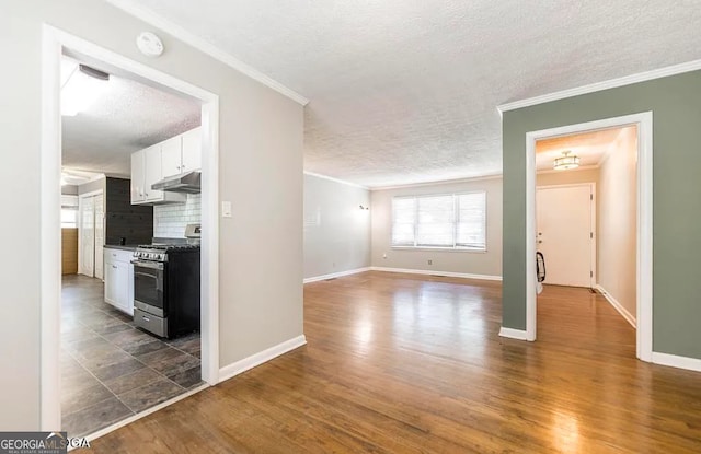 kitchen featuring white cabinetry, tasteful backsplash, dark hardwood / wood-style floors, a textured ceiling, and stainless steel range with gas stovetop