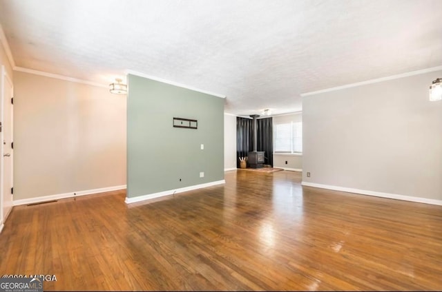 unfurnished living room featuring wood-type flooring and ornamental molding