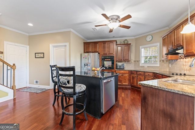 2202 Escalade Ct, Conyers, GA 30094 - kitchen with black appliances, ceiling fan, brown cabinets, a breakfast bar, and light stone countertops