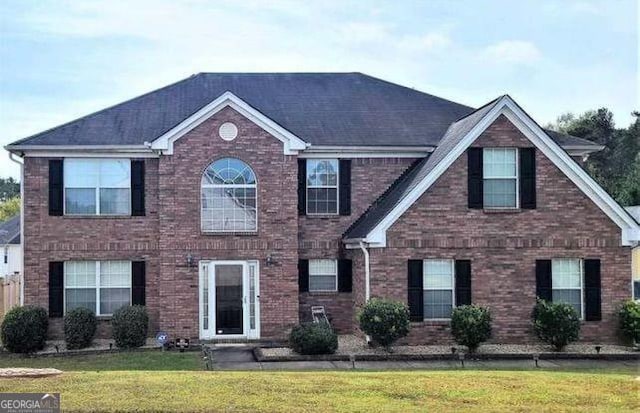 colonial home with a front lawn