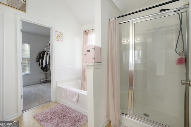 bathroom featuring lofted ceiling, a shower stall, a spacious closet, and a bath