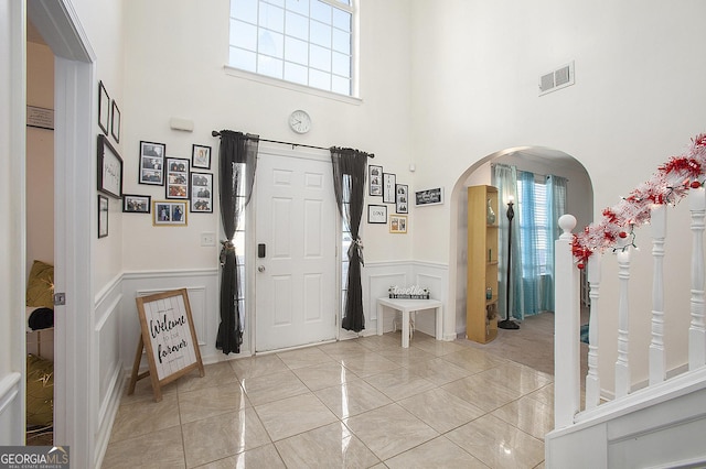 foyer with light tile patterned floors and a high ceiling