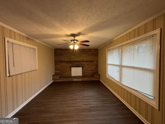 spare room featuring ceiling fan, dark hardwood / wood-style flooring, ornamental molding, and a textured ceiling