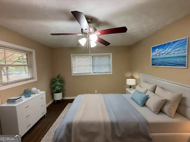 spare room with a textured ceiling, ceiling fan, ornamental molding, and dark wood-type flooring