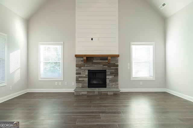 unfurnished living room with plenty of natural light, dark wood-type flooring, and high vaulted ceiling