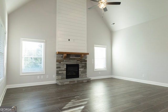 unfurnished living room featuring a fireplace, high vaulted ceiling, ceiling fan, and dark wood-type flooring