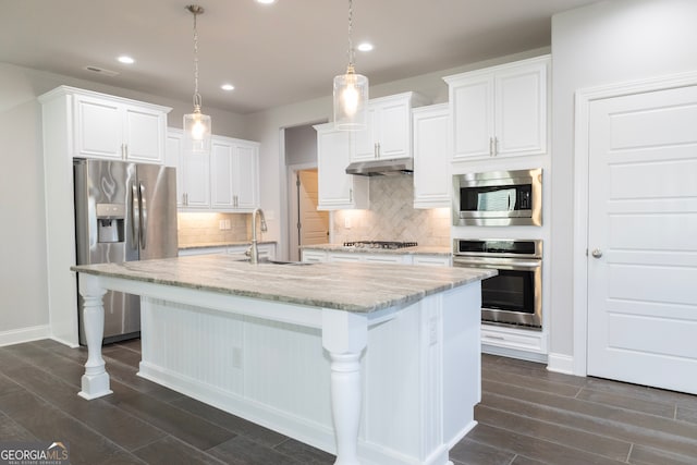 kitchen featuring a kitchen island with sink, sink, pendant lighting, and appliances with stainless steel finishes