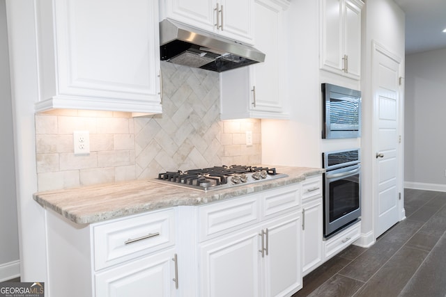 kitchen featuring dark hardwood / wood-style floors, light stone counters, white cabinetry, and stainless steel appliances