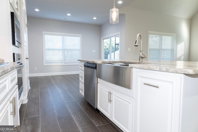 kitchen featuring stainless steel appliances, dark wood-type flooring, sink, decorative light fixtures, and white cabinetry