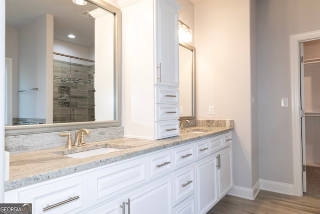 bathroom with hardwood / wood-style floors, vanity, and an enclosed shower