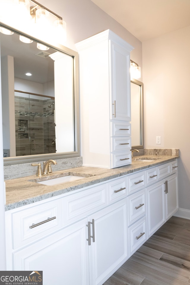 bathroom featuring hardwood / wood-style floors, vanity, and an enclosed shower