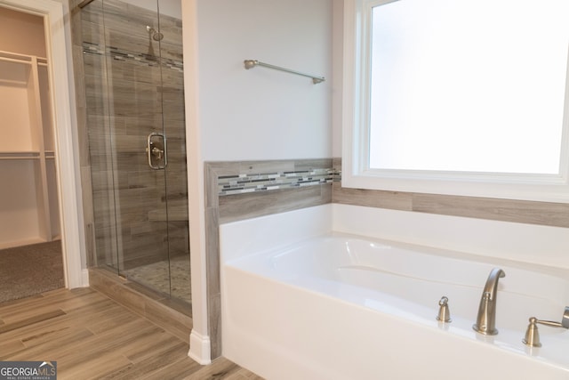 bathroom with hardwood / wood-style floors and separate shower and tub