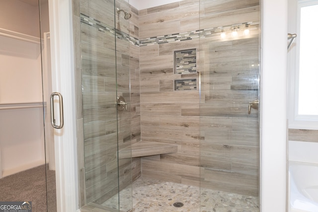 bathroom featuring a shower with shower door