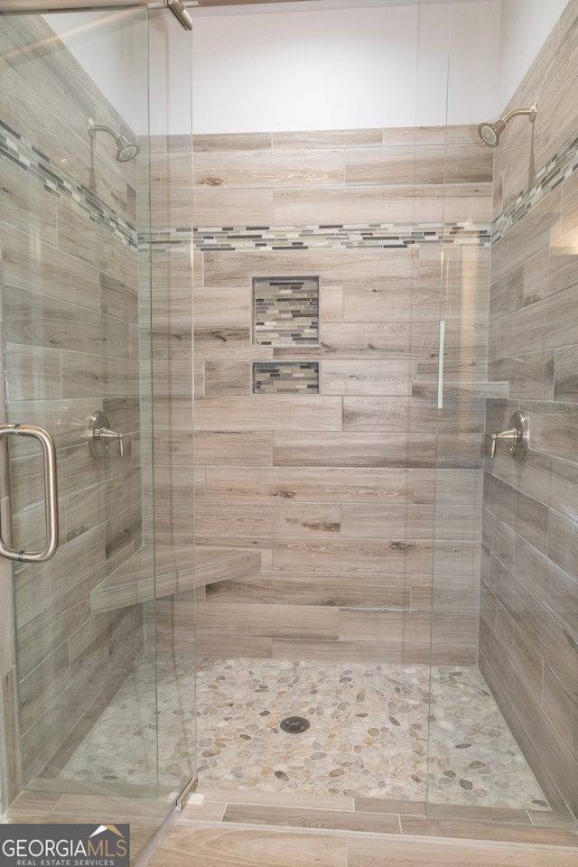 bathroom with a shower with door