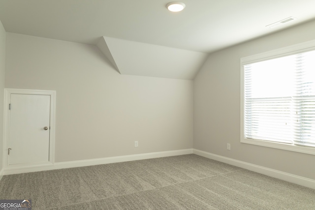 additional living space featuring light carpet and lofted ceiling