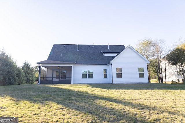 back of house featuring a sunroom and a lawn