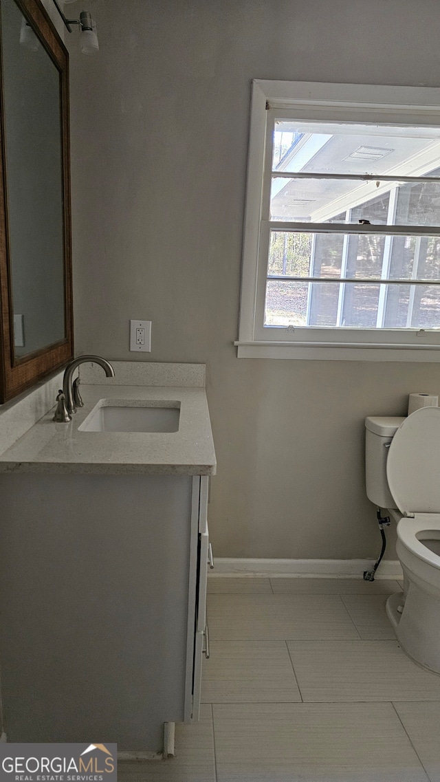 bathroom with tile patterned flooring, vanity, and toilet